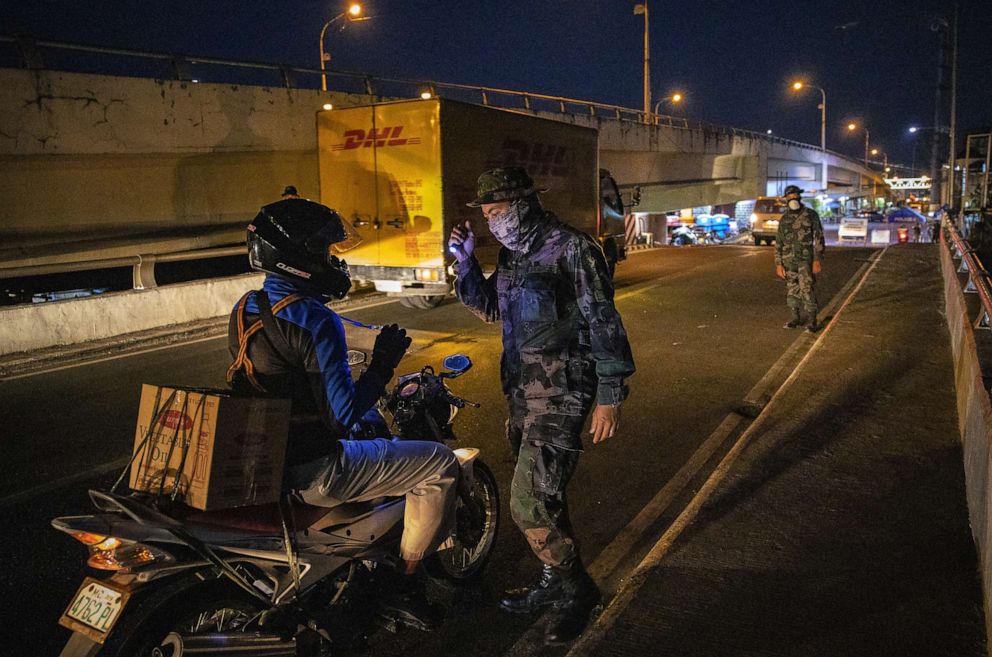 PHOTO: Soldiers inspect motorists at a quarantine checkpoint, March 31, 2020 in Las Pinas, Metro Manila, Philippines.