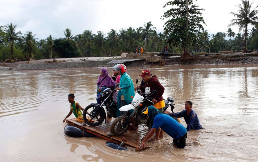 PHOTO: Residents on board a makeshift raft try to cross a river after a flood brought by tropical storm Tembin in Lanao del Norte province, Philippines, Dec. 23, 2017.