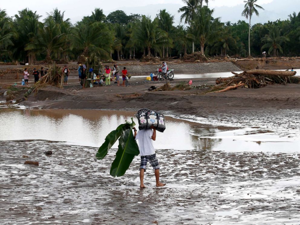PHOTO: A Filipino villager carries belongings in flood hit town of Salvador, Lanao del Norte province, Philippines, Dec. 23, 2017.