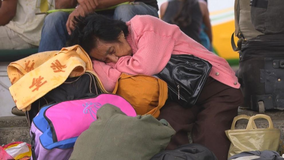 PHOTO: A Venezuelan woman falls asleep as she waits for her bus near the Simon Bolivar International Bridge in Cucuta, Colombia. For many Venezuelan migrants, the marathon journey out of their country continues farther into South America. 
