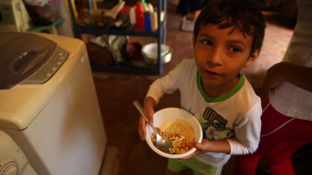 PHOTO: Vanessa Posada had not bought any protein in months. Here, her son eats the eggs Posada was able to buy for him. Any protein she buys goes to him.