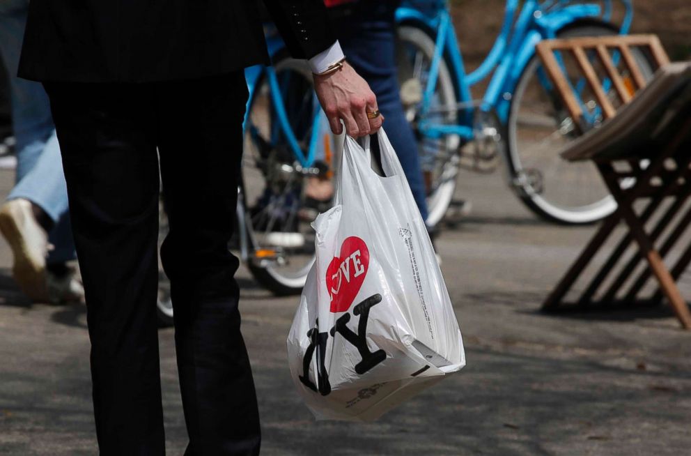 PHOTO: A man holds a plastic shopping bag as he visits Central Park on April 26, 2018 in New York. In April New York Gov. Andrew Cuomo called for a ban on plastic carryout bags at stores statewide. 