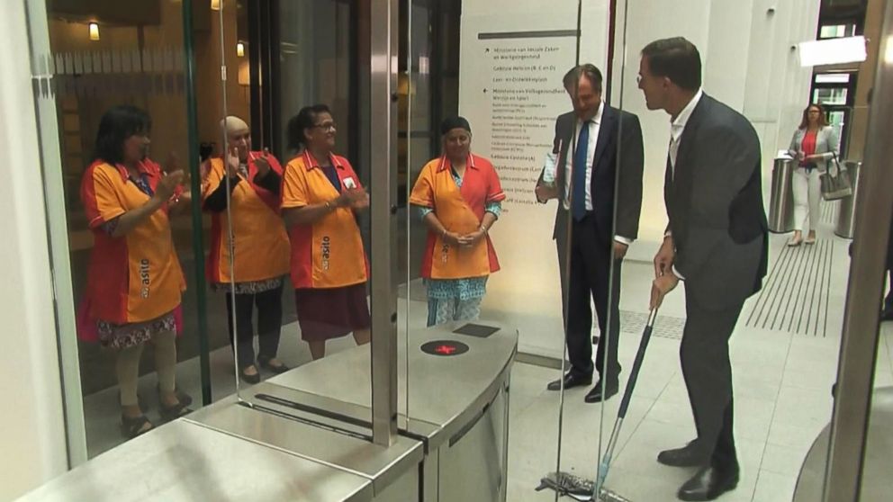 PHOTO: Mark Rutte, the prime minister of the Netherlands, spills his coffee and helps clean it up while walking through security gates ahead of the weekly coalition meeting, June 4, 2018.