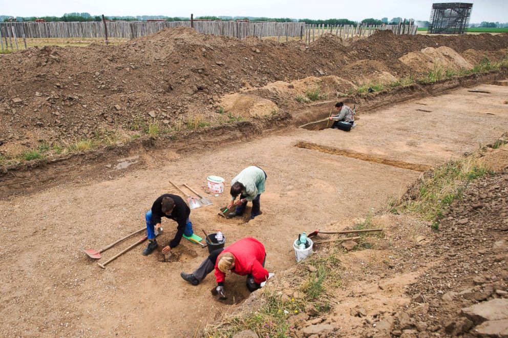 PHOTO: Excavation helpers work to help clear a longhouse beam from a Early Bronze Age settlement, June 5, 2018, Poemmelte, Germany.