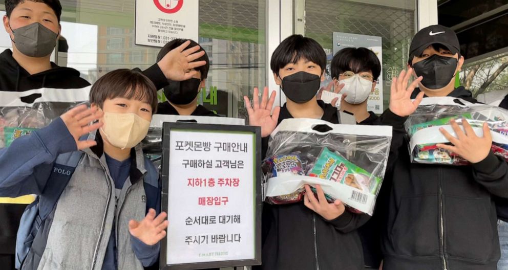 PHOTO: Teenagers who bought Pokemon breads stand in front of the wholesale store with bread in hands, Yongin, South Korea, April 9, 2022.