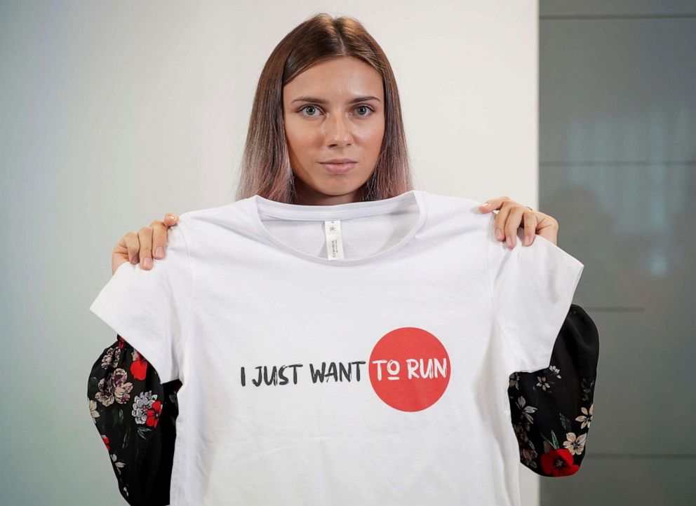 PHOTO: Belarusian sprinter Krystsina Tsimanouskaya, who left the Olympic Games in Tokyo and seeks asylum in Poland, holds a t-shirt at a news conference in Warsaw, Poland Aug. 5, 2021.