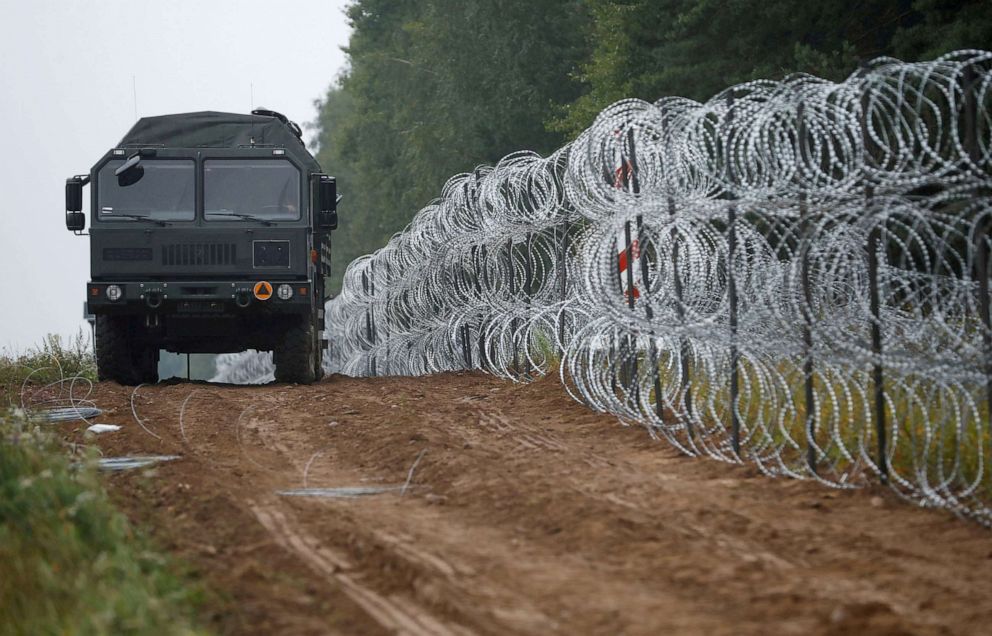 PHOTO: A vehicle on the road next to a fence built by Polish soldiers on the border between Poland and Belarus near the village of Nomiki, Poland, Aug. 26, 2021.