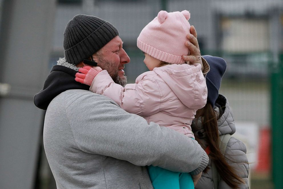 PHOTO: A father hugs his daughter as the family reunite after fleeing conflict in Ukraine, at the Medyka border crossing, in Poland, Feb. 27, 2022.