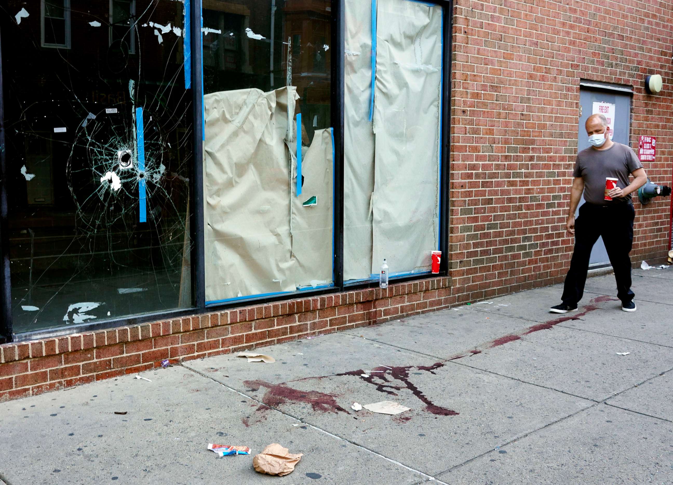 PHOTO: A person walks past the scene of a fatal overnight shooting on South Street in Philadelphia, June 5, 2022.