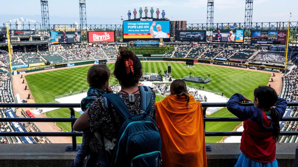 PHOTO: People listen during a public celebration hosted by the Chicago White Sox and the Archdiocese of Chicago for the election of Pope Leo XIV, featuring a mass at Rate Field in Chicago, June 14, 2025. 
