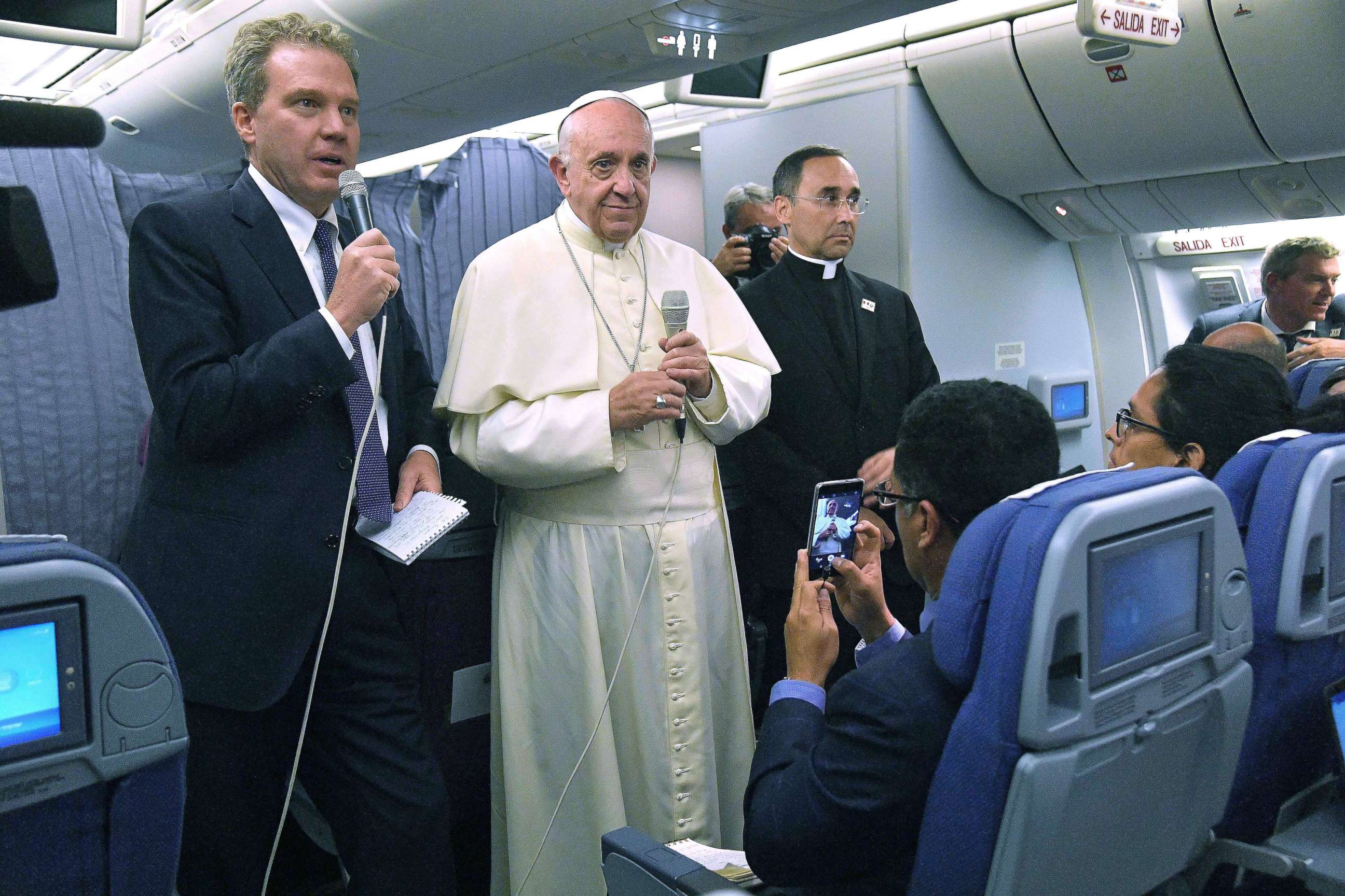 Greg Burke, left, Director of Holy See Press Office, speaks to journalists next to Pope Francis and Mons. Mauricio Rueda, delegate for the organization of papal journeys, aboard his flight to Italy at the end his visit to South America, Jan. 22, 2018.