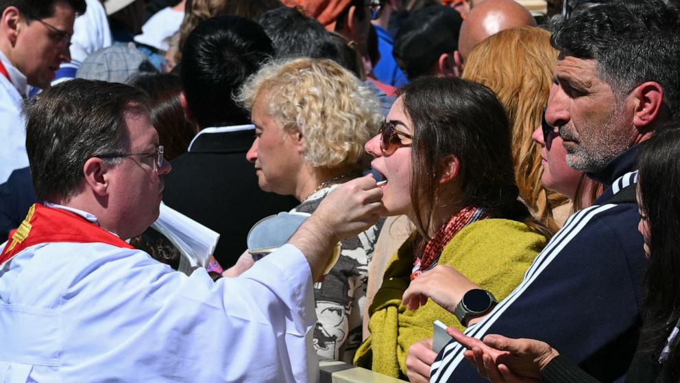 PHOTO: Attendees receive communion wafers during late Pope Francis' funeral at St Peter's Square in the Vatican, April 26, 2025. 