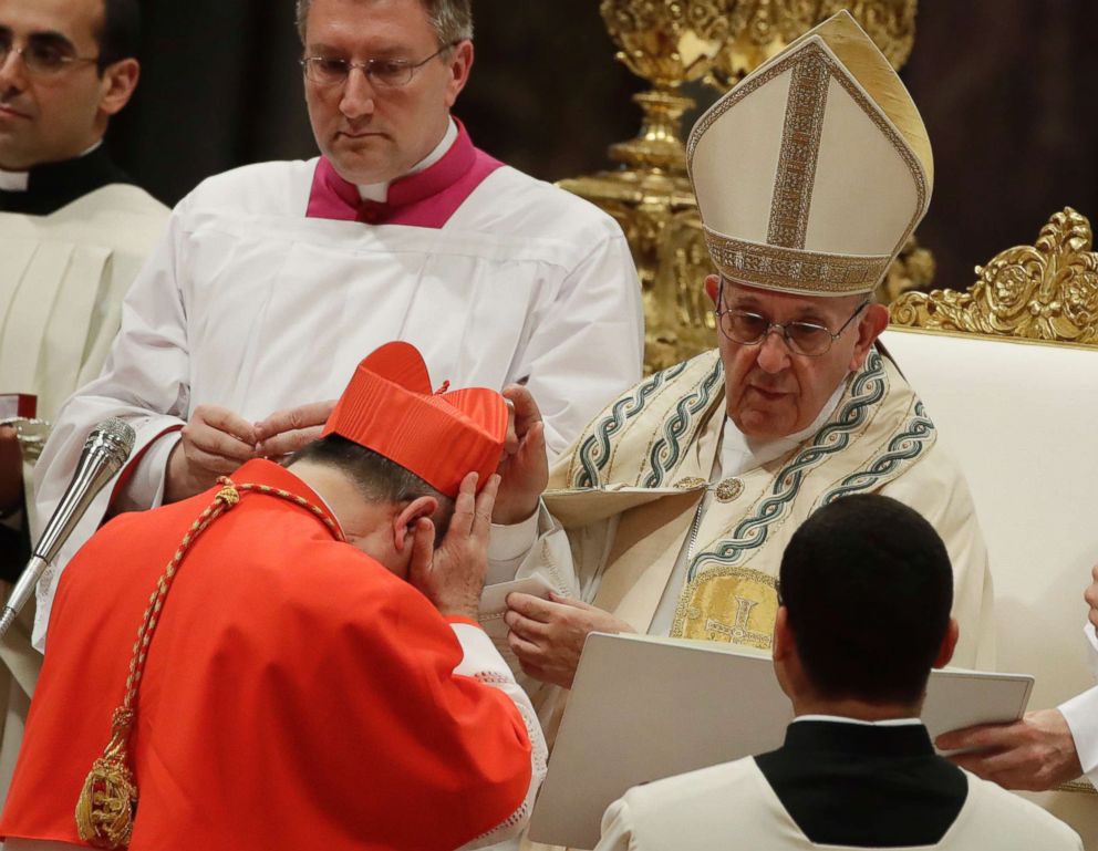 PHOTO: New Cardinal Giovanni Angelo Becciu receives the red three-cornered biretta hat from Pope Francis during a consistory in St. Peter's Basilica at the Vatican, June 28, 2018.