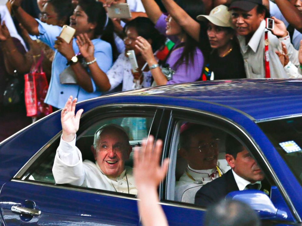 PHOTO: Pope Francis waves as as he is welcomed by the crowd along a road in Yangon, Myanmar, Nov. 27, 2017.
