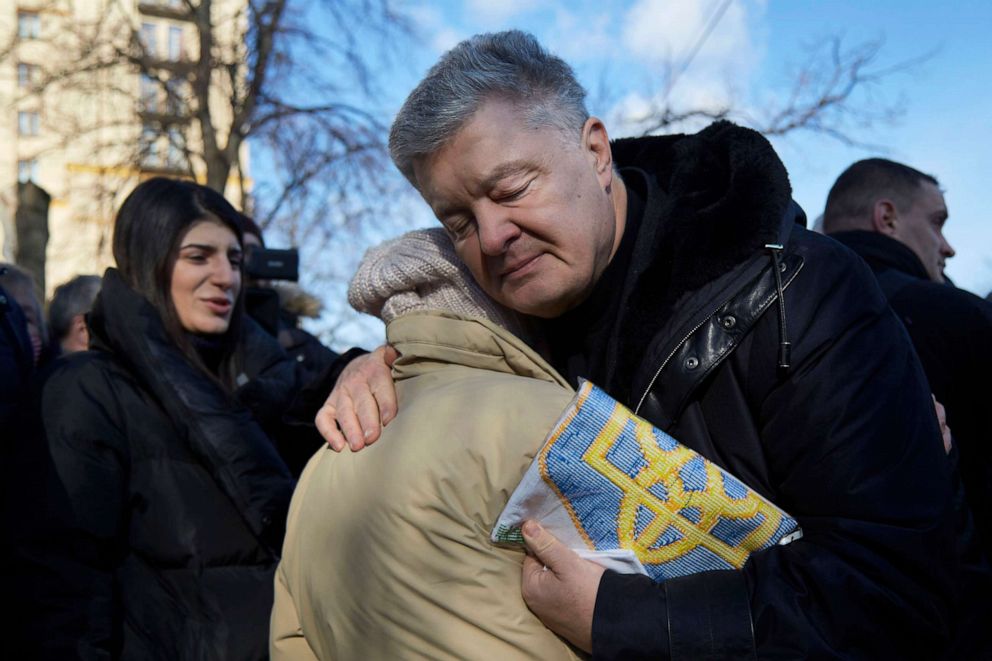 PHOTO: Former president of Ukraine Petro Poroshenko embraces a woman who gave him a Ukrainian flag during a Maidan Revolution commemoration ceremony on Feb. 20, 2022, in Kyiv, Ukraine.