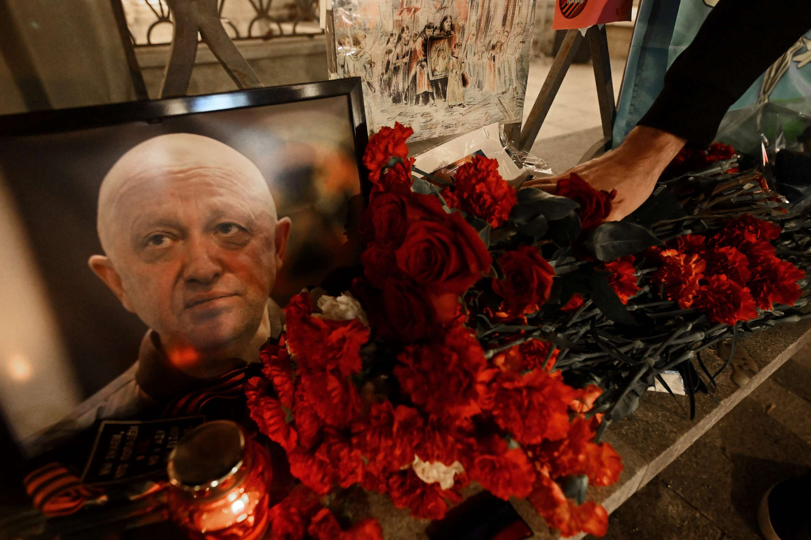 PHOTO: A man lays flowers at the makeshift memorial in honor of Yevgeny Prigozhin and Dmitry Utkin, a shadowy figure who managed Wagner's operations and allegedly served in Russian military intelligence, in Moscow, on August 24, 2023.