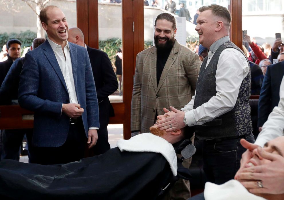 PHOTO: Britain's Prince William, Duke of Cambridge, speaks to Tom Chapman, founder of the charity Lions Barber Collective (C), and barber Daniel Davies (R), during a visit to Pall Mall Barbers in London, Feb. 14, 2019.