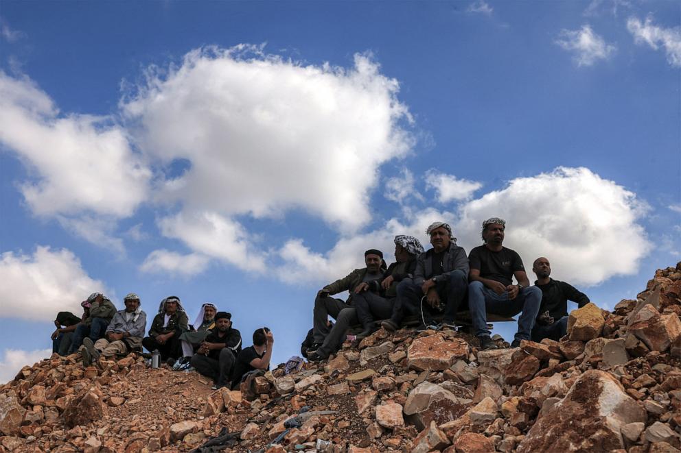 PHOTO: People gather to watch from a hilltop near Ofer military prison located between Ramallah and Beitunia in the occupied West Bank on October 13, 2025.