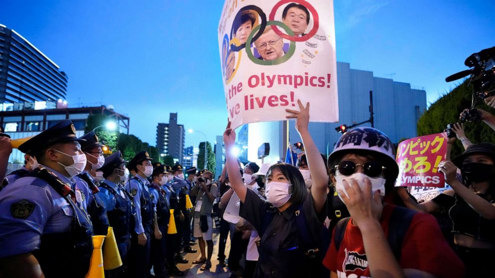 PHOTO: Anti-Olympics protesters, right, stage a rally in front of lines of policemen near National Stadium in Tokyo Friday, July 23, 2021.