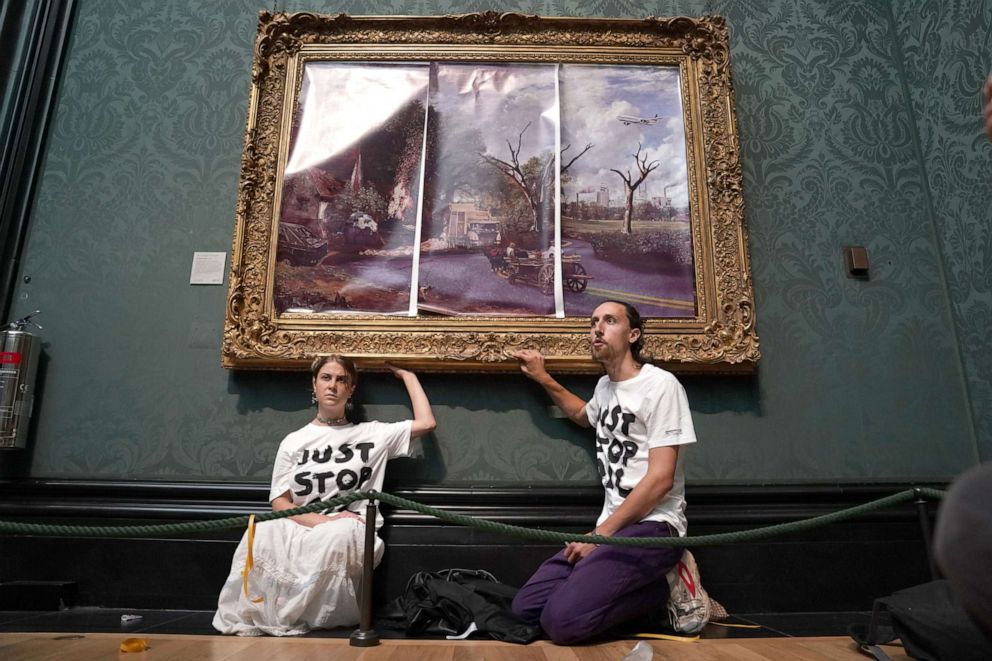 PHOTO: Protesters from Just Stop Oil climate protest group, glue their hands to the frame of John Constable's The Hay Wain after first having covered the painting with their own picture inside the National Gallery, London, July 4, 2022. 