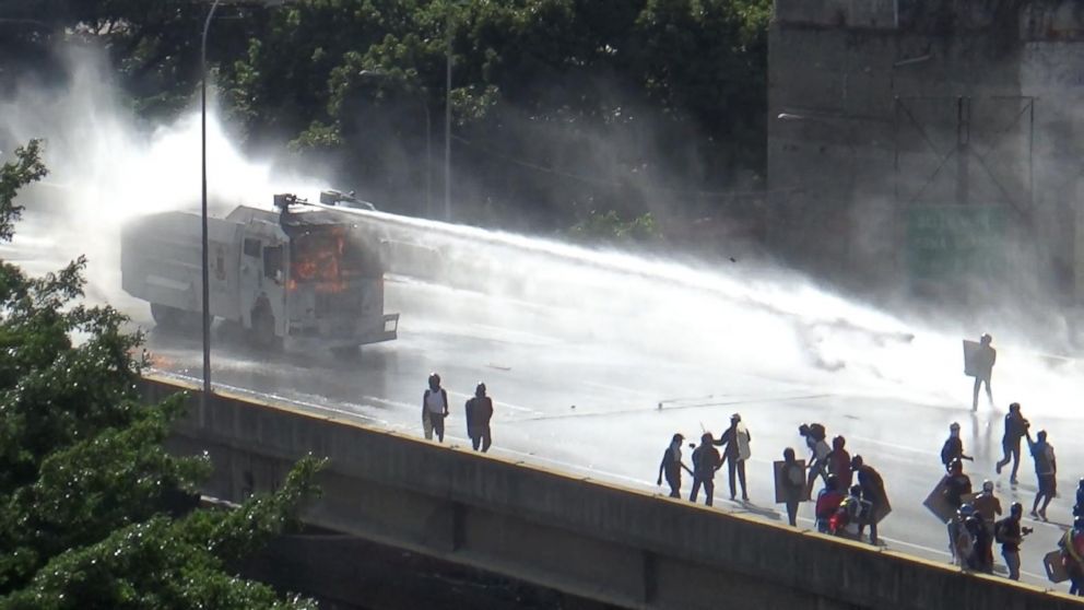 PHOTO: A police vehicle sprays anti-government protesters with a water canon in Caracas, Venezuela.