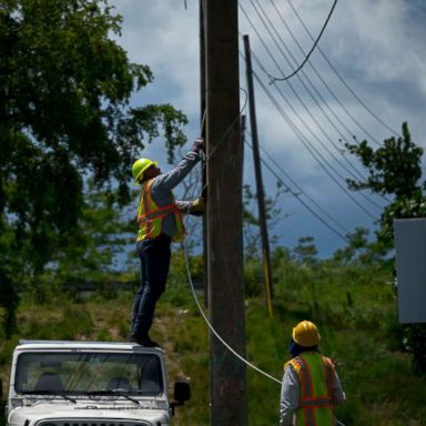 PHOTO: Workers of the electric repair brigade remove old cables from a post in San German, Puerto Rico, May 30, 2018.