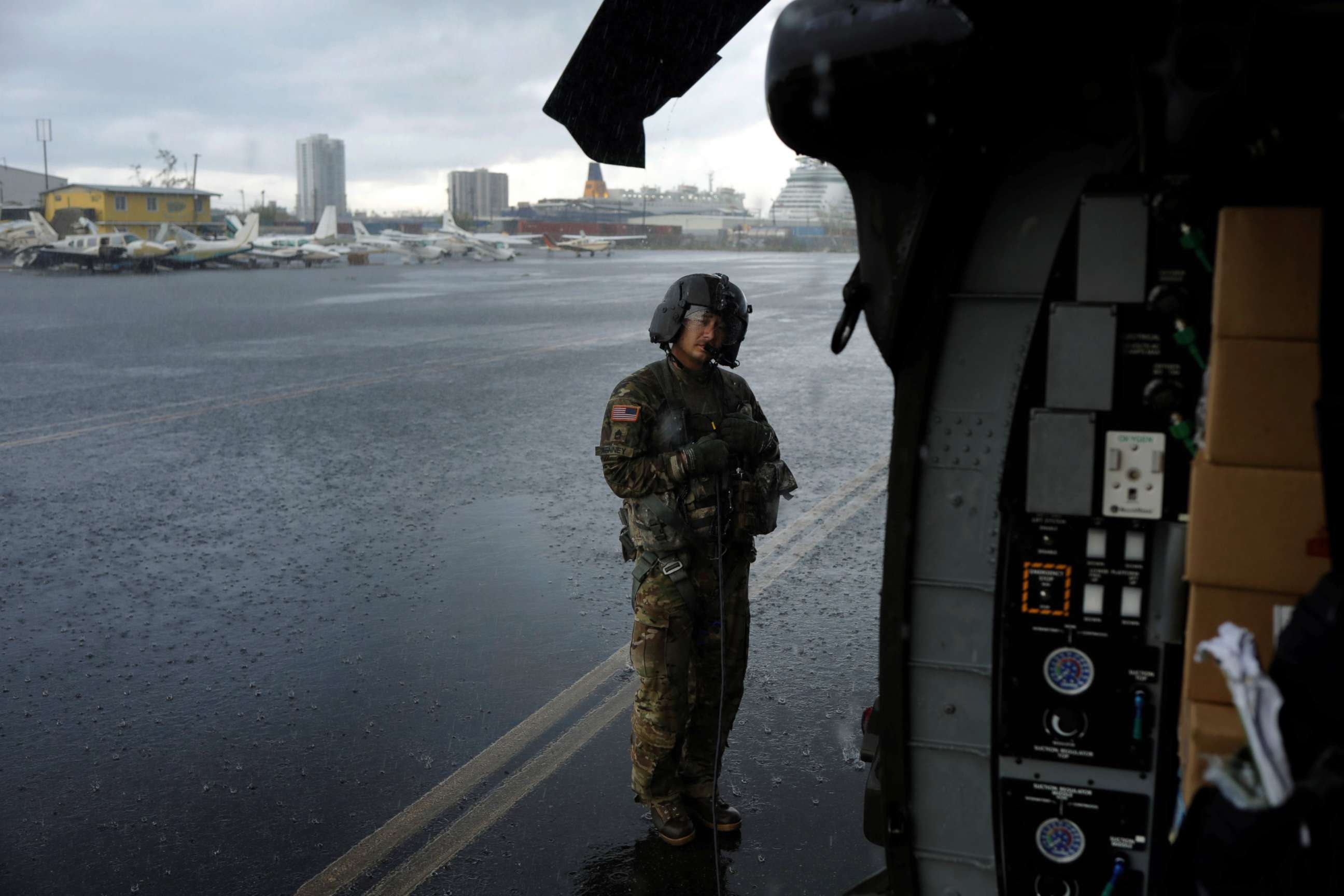 PHOTO: Crew chief Kenney shelters under the blade of an HH-60 Blackhawk helicopter from 101st Airborne Division's "Dustoff" unit preparing to take off during recovery efforts following Hurricane Maria, in Isla Grande, Puerto Rico, Oct. 6, 2017. 