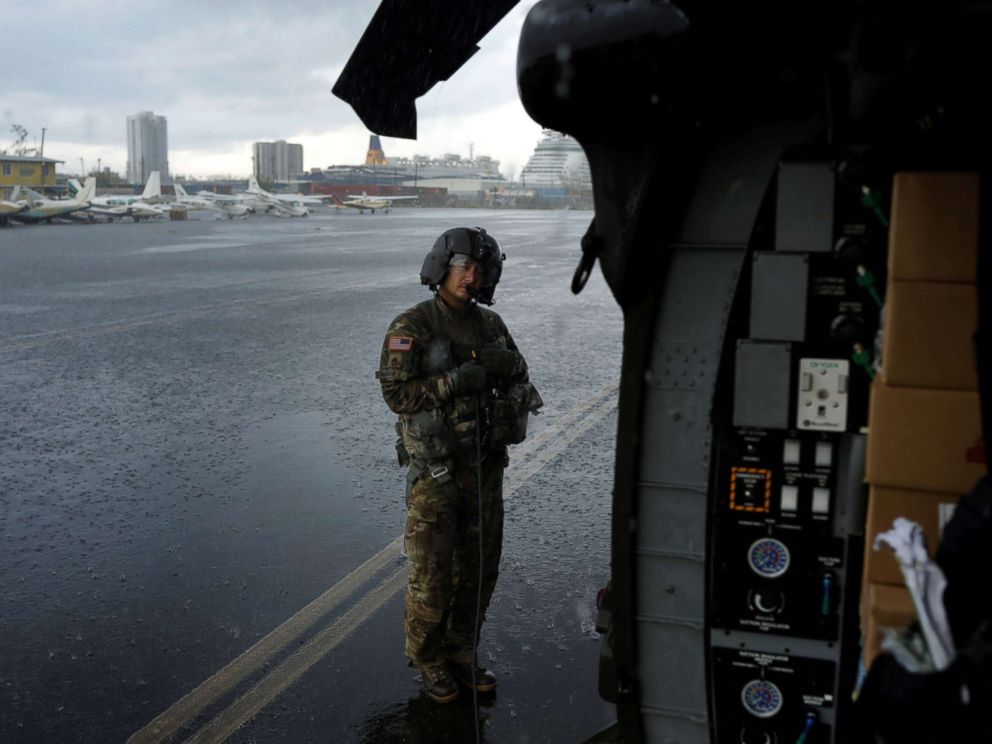 PHOTO: Crew chief Kenney shelters under the blade of an HH-60 Blackhawk helicopter from 101st Airborne Divisions Dustoff unit preparing to take off during recovery efforts following Hurricane Maria, in Isla Grande, Puerto Rico, Oct. 6, 2017.