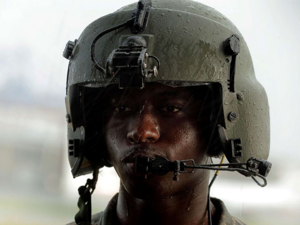 PHOTO: Crew member Bynum stands in tropical rain as a HH-60 Blackhawk helicopter from 101st Airborne Divisions Dustoff unit prepares to take off during recovery efforts following Hurricane Maria, in Isla Grande, Puerto Rico, Oct. 6, 2017.