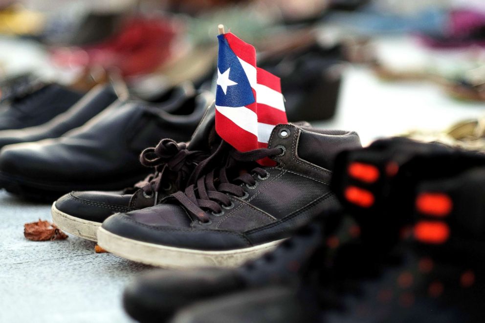 PHOTO: A Puerto Rican flag is placed on a pair of shoes among hundreds displayed in memory of those killed by Hurricane Maria in San Juan on June 1, 2018.