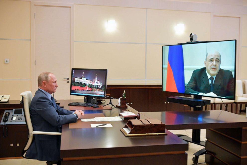 PHOTO:Russian President Vladimir Putin listens to Russian Prime Minister Mikhail Mishustin, displayed on TV screen on the right, during their meeting via teleconference at the Novo-Ogaryovo residence outside Moscow, Russia, April 30, 2020.