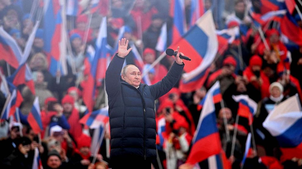 PHOTO: Russian President Vladimir Putin greets the audience as he attends a concert marking the eighth anniversary of Russia's annexation of Crimea at the Luzhniki stadium in Moscow, March 18, 2022.