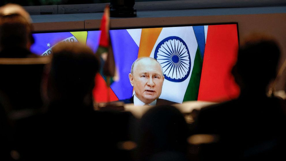 PHOTO: A screen shows Russian President Vladimir Putin virtually delivering remarks as delegates look on while attending a meeting during the 2023 BRICS Summit at the Sandton Convention Centre in Johannesburg on August 24, 2023.