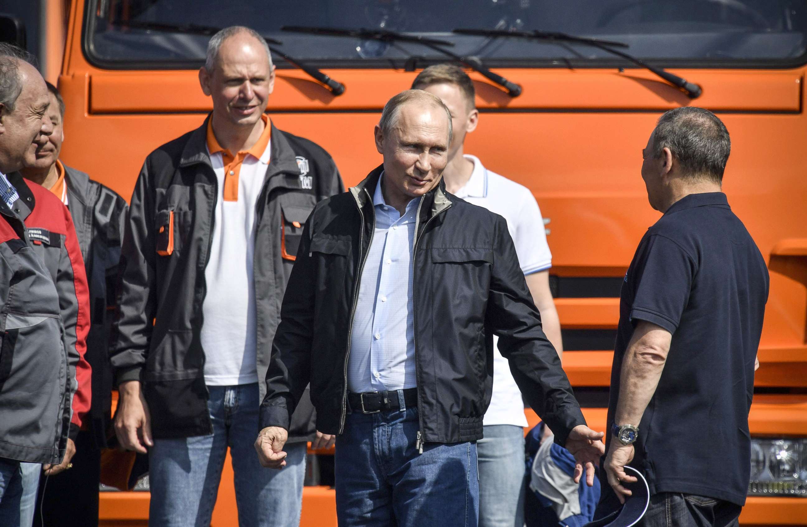 PHOTO: Russian President Vladimir Putin (C) talks to workers after driving a construction truck across the new 12 miles road-and-rail Crimean Bridge over the Kerch Strait that links mainland Russia to Moscow-annexed Crimea, May 15, 2018.