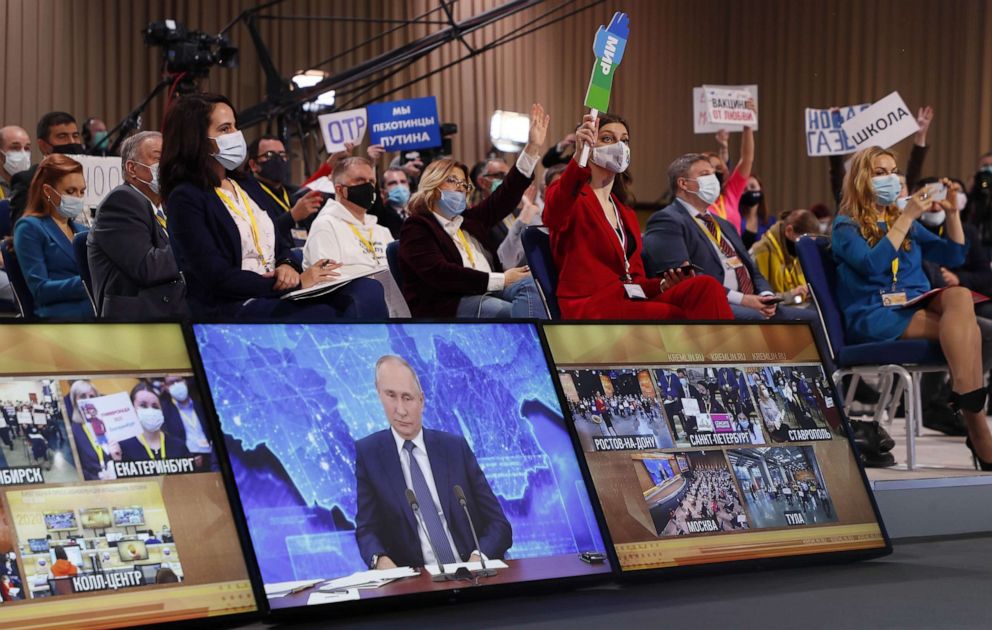 PHOTO: Journalists look at a screen showing Russian President Vladimir Putin during his annual press conference via a video link from the Novo-Ogaryovo state residence, at the World Trade Center in Moscow, Dec. 17, 2020.
