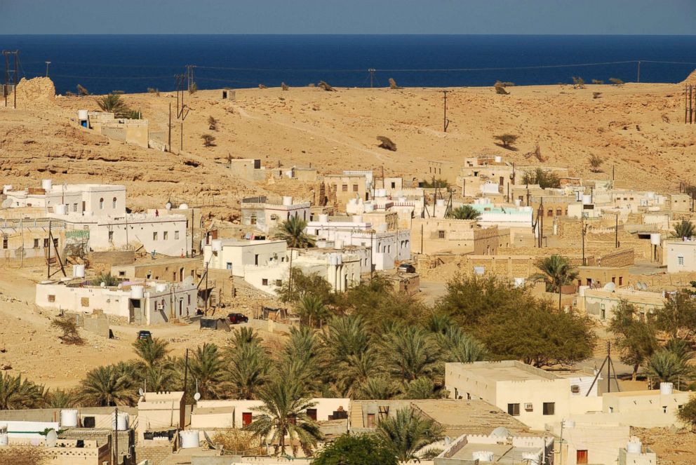 PHOTO: An elevated view of small houses and trees in an arid area of Qalhat, Oman.