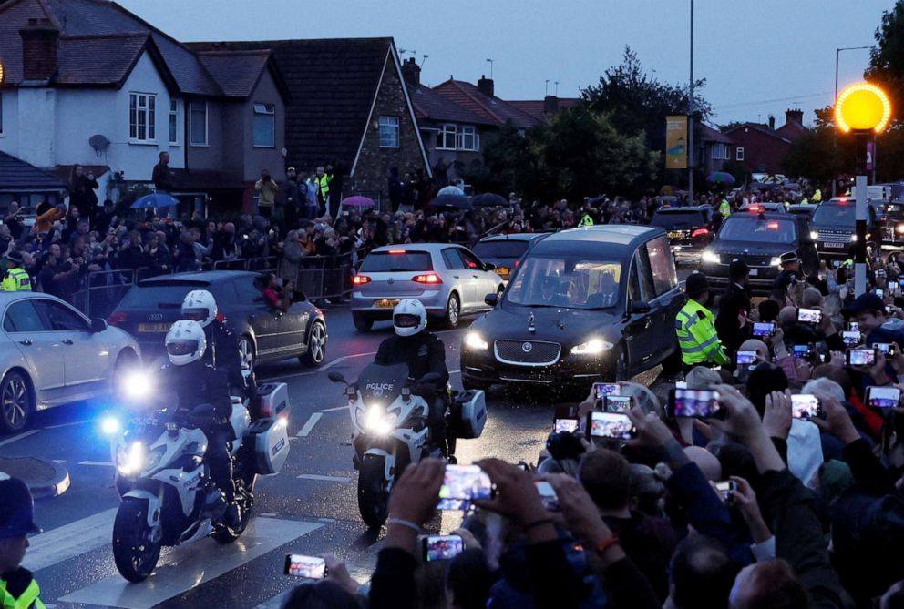 PHOTO: People watch the hearse carrying the coffin of Britain's Queen Elizabeth, following her death, after leaving RAF Northolt, in London, Sept. 13, 2022.