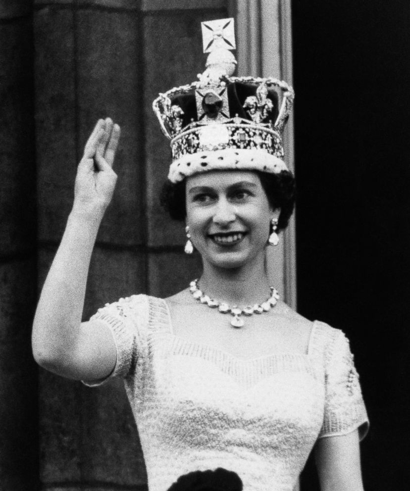 PHOTO: Queen Elizabeth II, wearing the Imperial Crown, smiles and waves to a crowd from balcony of Buckingham Palace on June 3, 1953, in London, on returning from Westminster Abbey following her coronation.