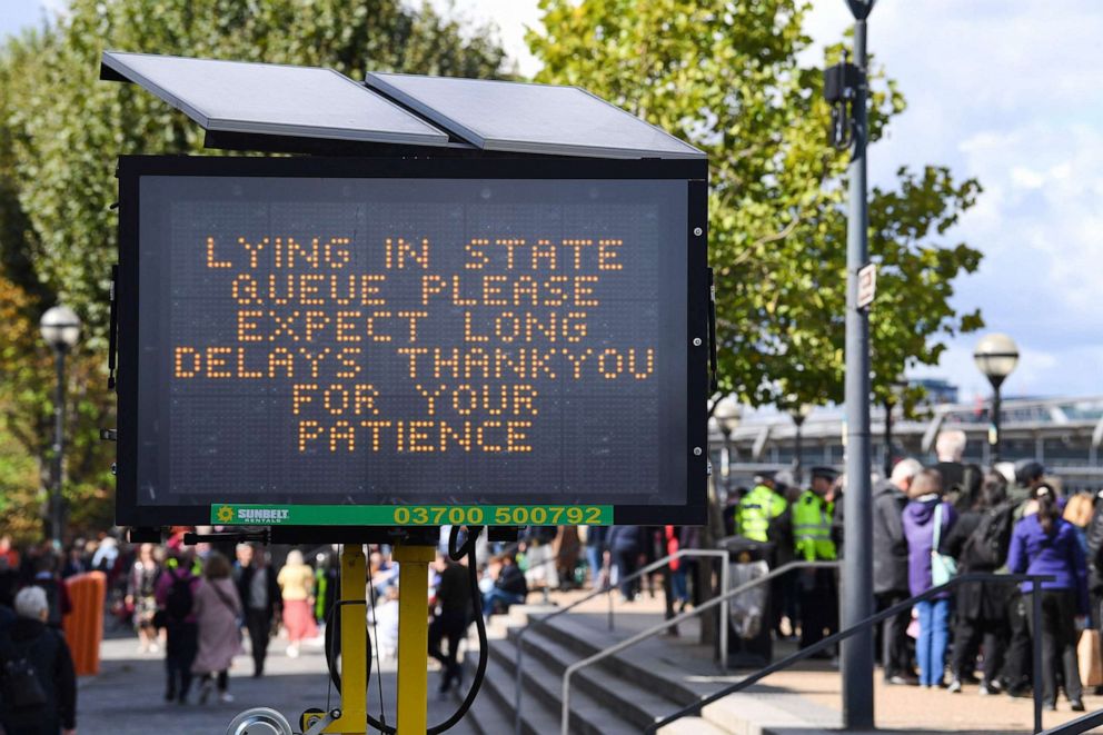 PHOTO: A digital sign displays information about queueing time as members of the public stand in the queue, as they wait in line to pay their respects to the late Queen Elizabeth II, in London on Sept. 16, 2022.