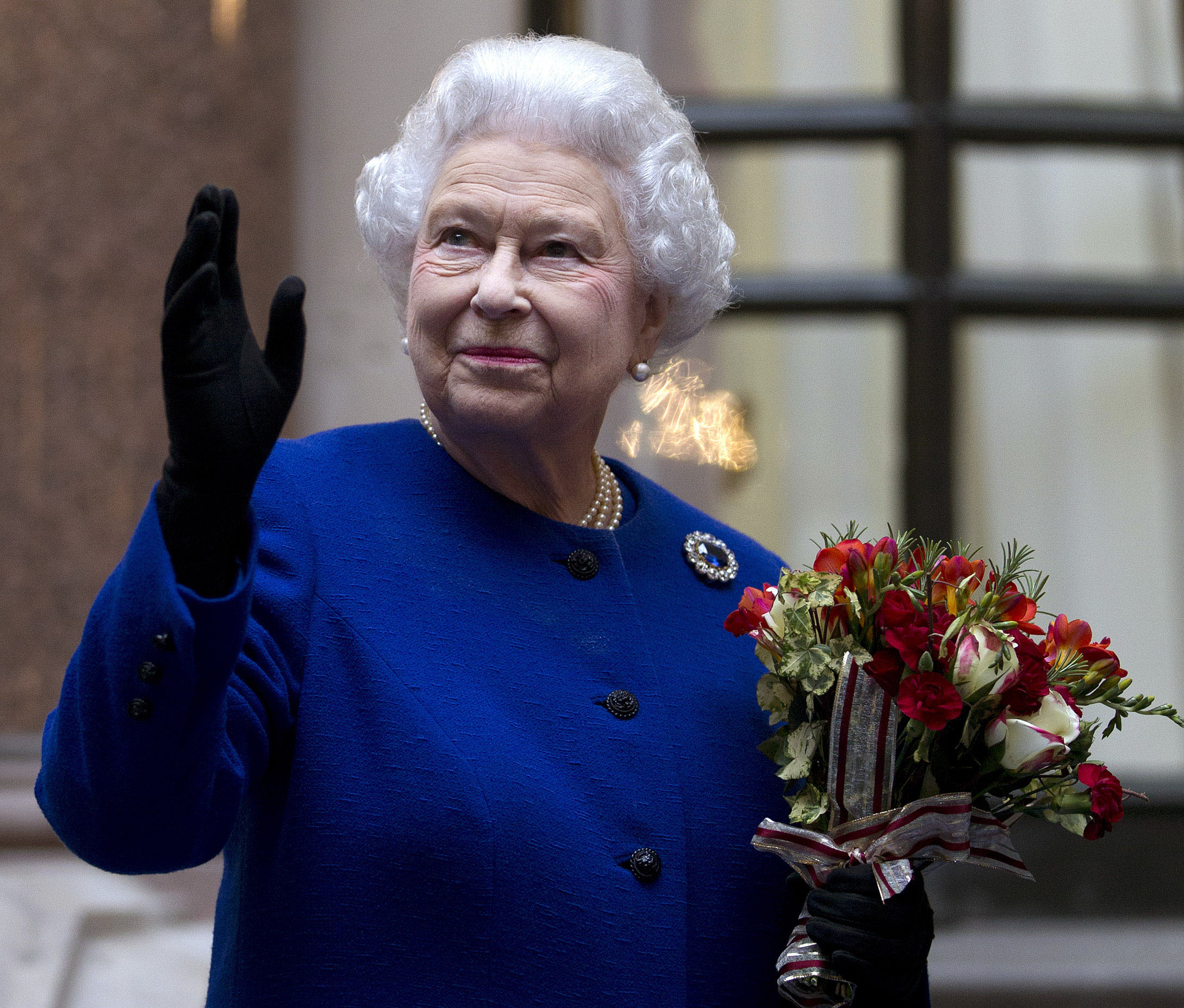 PHOTO: Britain's Queen Elizabeth II looks up and waves to members of staff of The Foreign and Commonwealth Office as she ends an official visit, which is part of her Jubilee celebrations in London, Dec. 18, 2012.