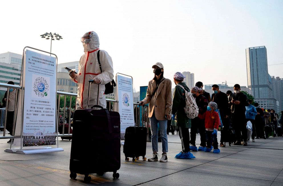 PHOTO: People wearing face masks arrive at Hankou Railway Station in Wuhan to take one of the first trains leaving the city in China's central Hubei province early on April 8, 2020.