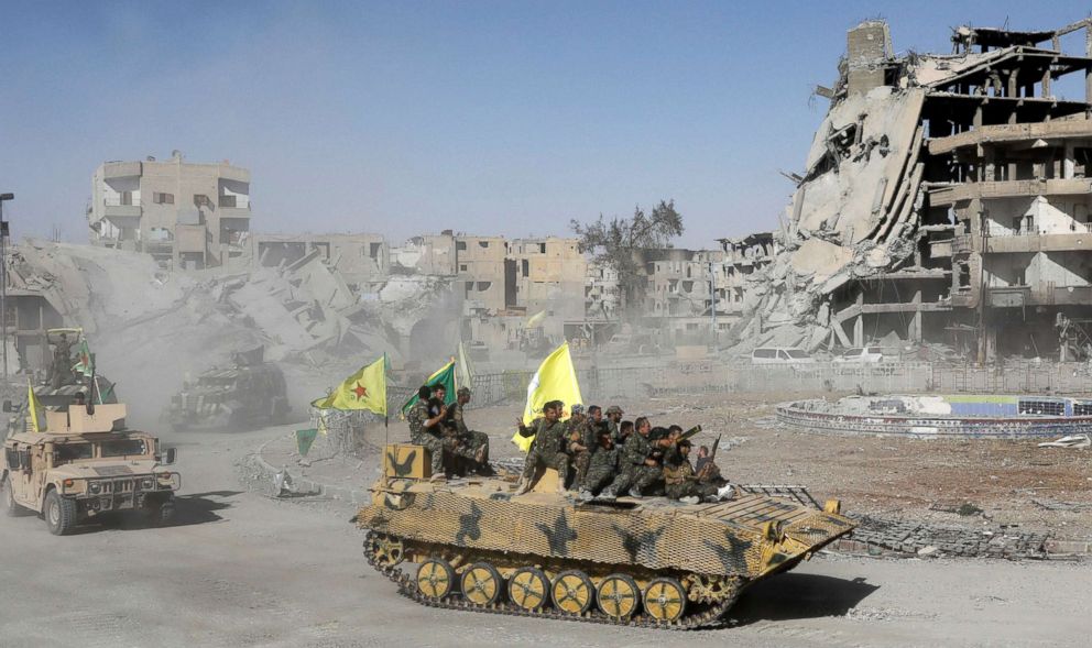 PHOTO: Syrian Democratic Forces (SDF) fighters ride atop of military vehicles as they celebrate victory in Raqqa, Syria, Oct. 17, 2017. 