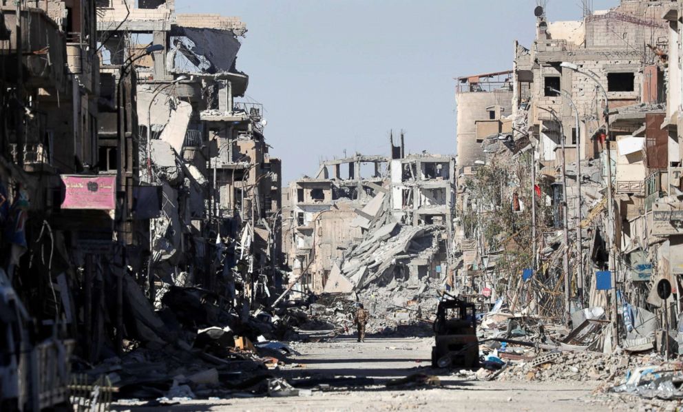 PHOTO: A fighter of Syrian Democratic Forces walks amidst the ruins of buildings in Raqqa, Syria, Oct. 18, 2017. 