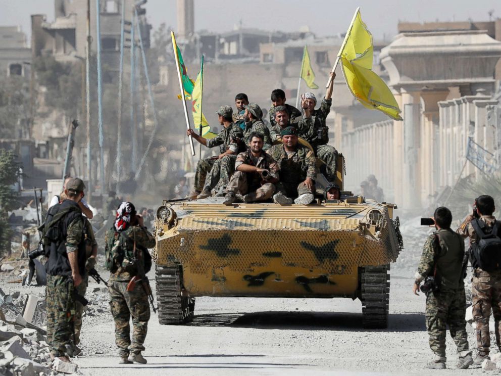 PHOTO: Fighters of Syrian Democratic Forces ride atop of an armoured vehicle after Raqqa was liberated from the Islamic State militants, in Raqqa, Syria, Oct. 17, 2017.
