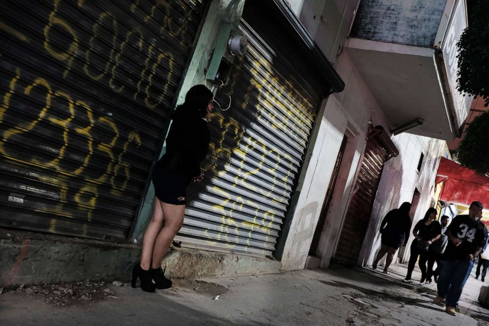 PHOTO: In this Jan. 20, 2019, file photo, a woman pauses in Zona Norte, the Red Light district known for its sex workers, in Tijuana, Mexico.