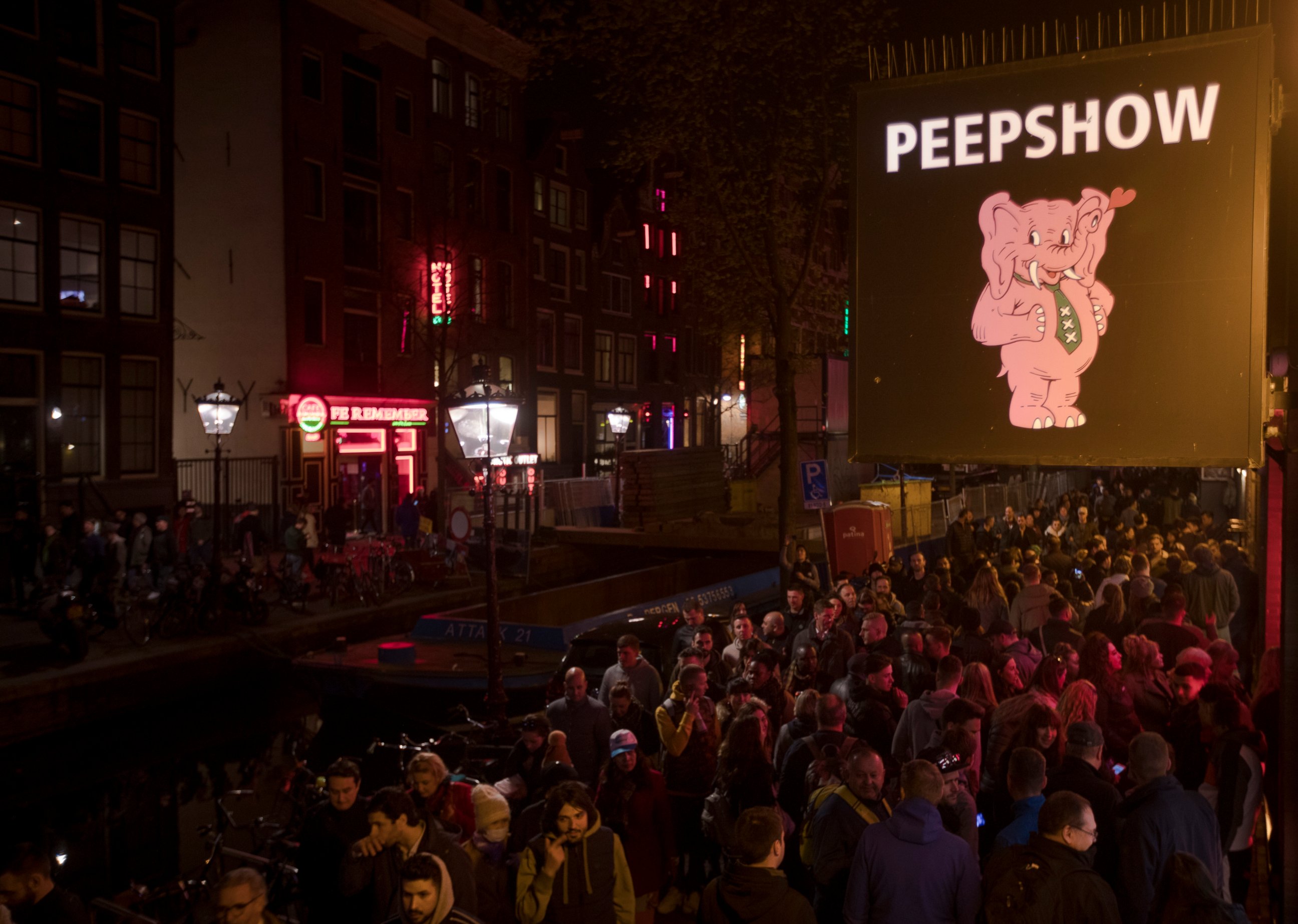 PHOTO: Tourists are bathed in a red glow emanating from the windows and peep shows' neon lights are packed shoulder to shoulder as they shuffled through the alleys in Amsterdam's red light district, Netherlands, Friday evening, March 29, 2019.