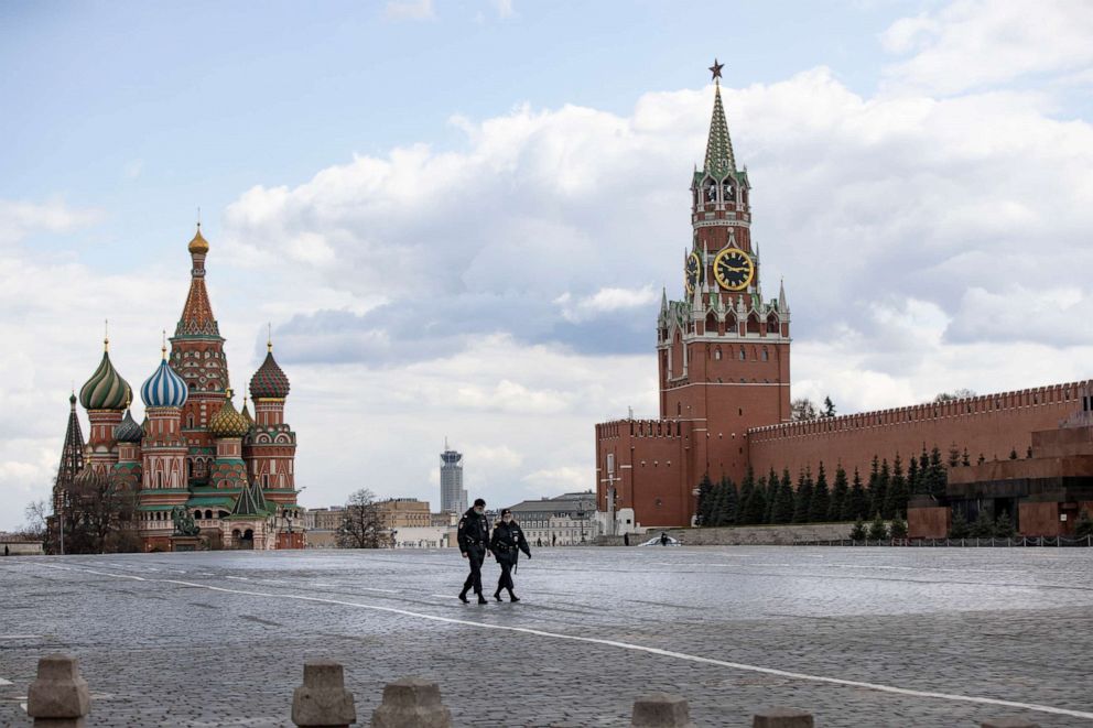 PHOTO: Two police officers patrol an almost empty Red Square, with St. Basil's Cathedral (center) and Spasskaya Tower in Moscow, Russia, on April 20, 2020. 