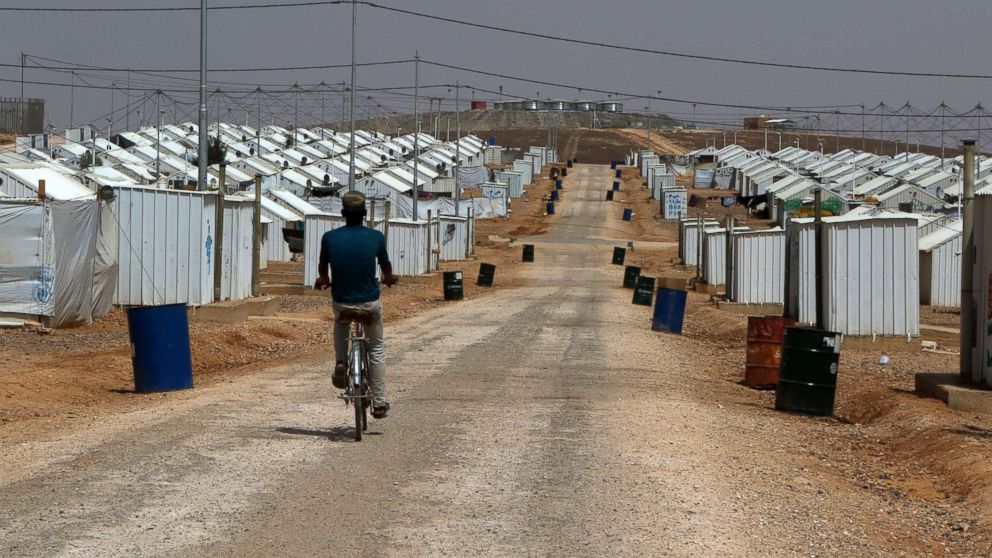 PHOTO: A Syrian refugee boy rides his bike under the hot sun near his makeshift home at the Azraq camp for Syrian refugees, the newest camp in Jordan that hosts 54.000 refugees in northeastern desert in Azraq, Jordan, July 13, 2017. 