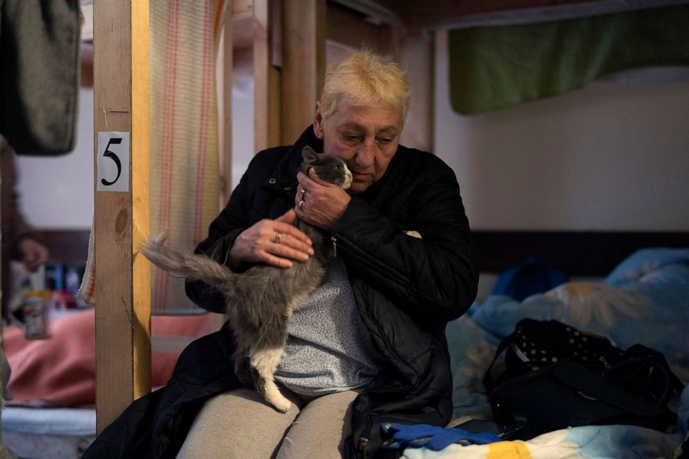 PHOTO: Alexandra Kusminova pets her cat, named Mouse, on a bed set up in a restaurant transformed into a shelter for internally displaced people from the eastern region, in Dnipro, Ukraine, April 20, 2022.