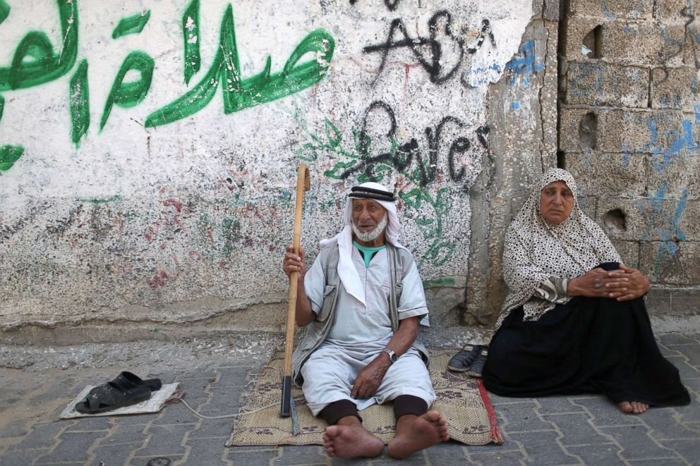 PHOTO: Palestinians sit outside their house at Khan Younis refugee camp in the southern Gaza Strip, June 20, 2018.